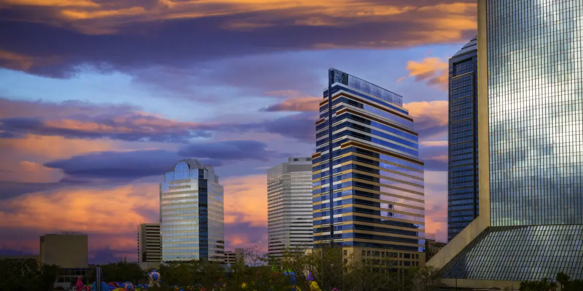 Vibrant Jacksonville City Skyline and Buildings with dramatic saturated cloudscape over the Riverfront Plaza Park in North Florida, USA.